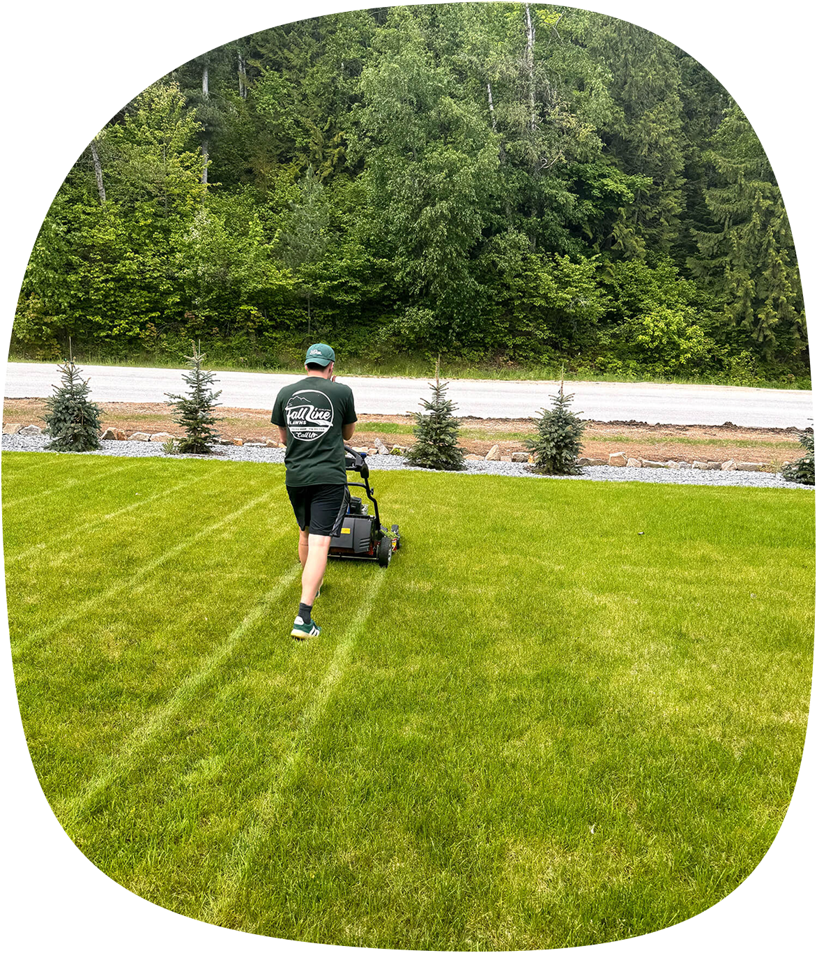 Fall Line Lawns team mowing a lawn in Revelstoke